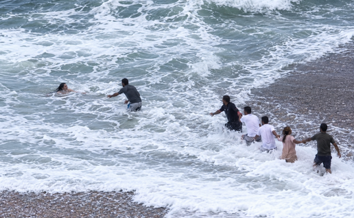 Passersby race to rescue of woman washed out to sea.