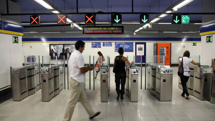 Passengers passing through ticket barriers at a Madrid Metro station