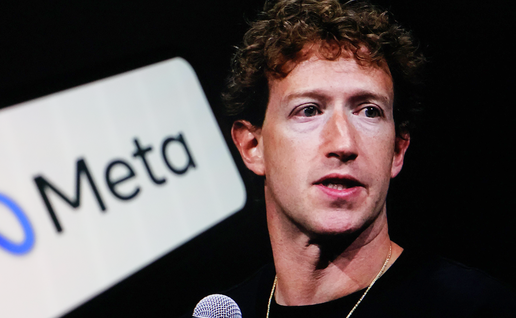 Mark Zuckerberg with curly dark hair speaks into a microphone beside a large Meta logo against a black background.