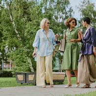 Three women walking through a park.