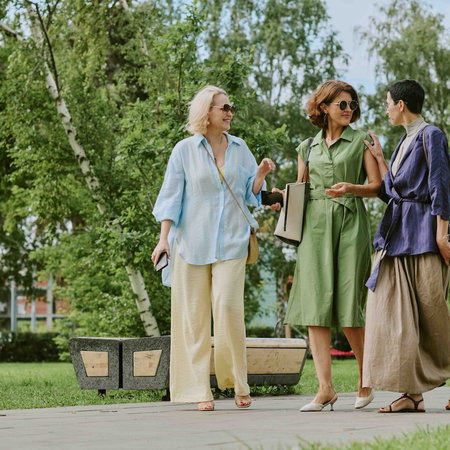Three women walking through a park.