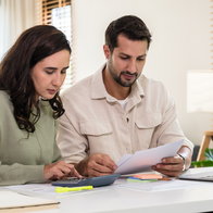 Couple reviewing financial documents and calculating costs as mortgage interest rates rise at 11 banks in Spain.