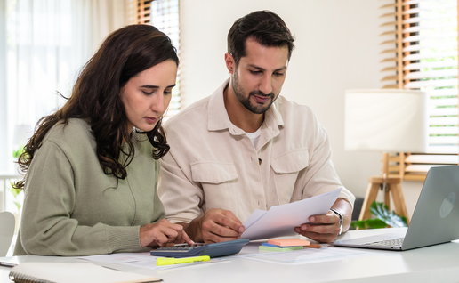Couple reviewing financial documents and calculating costs as mortgage interest rates rise at 11 banks in Spain.