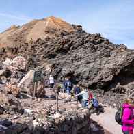 Tourists walking along a rocky trail on Mount Teide, Tenerife