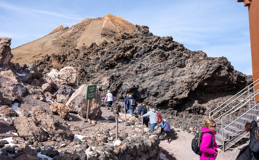 Tourists walking along a rocky trail on Mount Teide, Tenerife