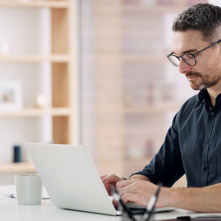 Man using a laptop as Spain warns of fake investment websites.