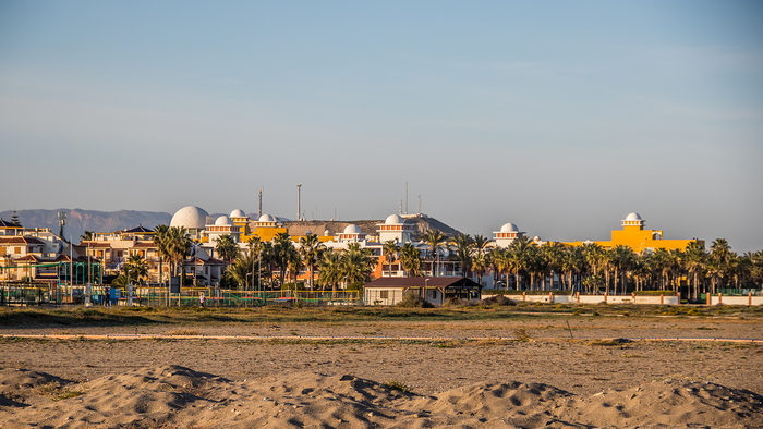 Seafront homes and palm trees beside the beach at Vera Playa in Almería, Spain