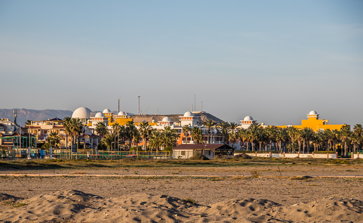Seafront homes and palm trees beside the beach at Vera Playa in Almería, Spain