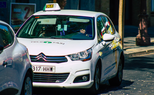 A taxi on the road queued behind another car.