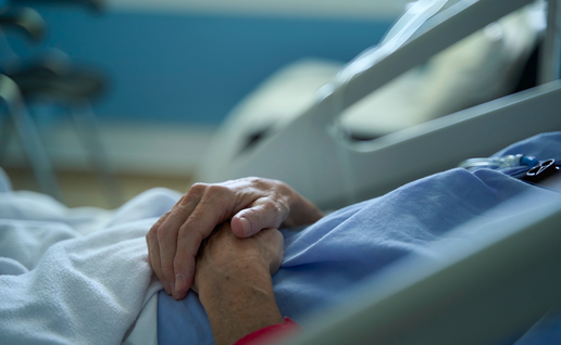 Hands on a man lying on a hospital bed