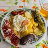 A traditional meal from Spain with fried egg, potatoes, black pudding, ham and fried peppers