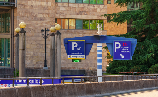 An entrance to an underground parking with two 'P' signs on either side of the road