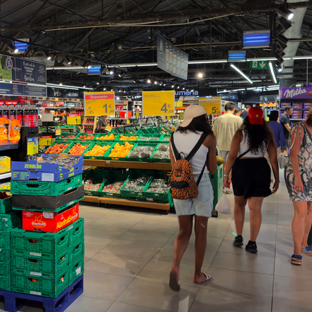 Shoppers in a supermarket surrounded by produce