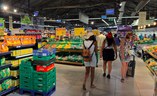 Shoppers in a supermarket surrounded by produce
