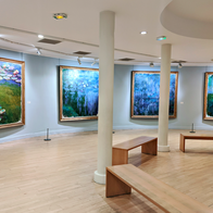 A museum room with paintings of Claude Monet and wooden benches in front of them