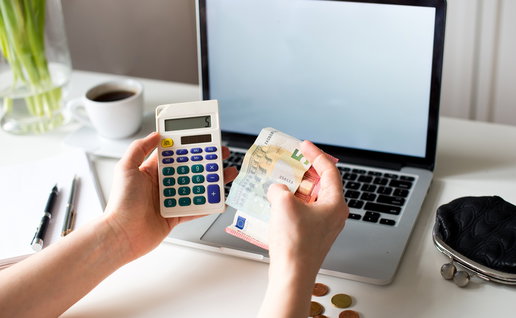 Worker calculating salary deductions with euro banknotes