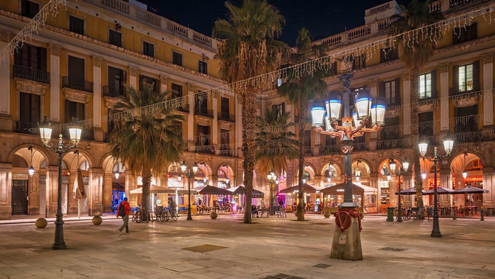 Public street lights illuminating a Spanish city square at night