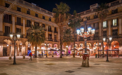 Public street lights illuminating a Spanish city square at night