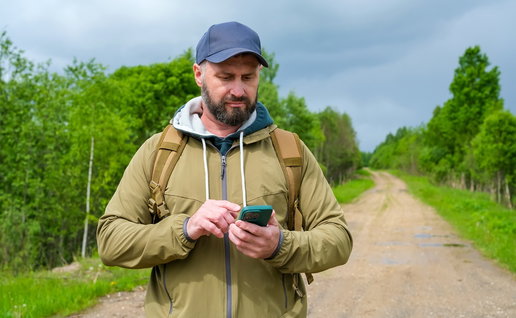 tourist checking directions on a smartphone in the countryside