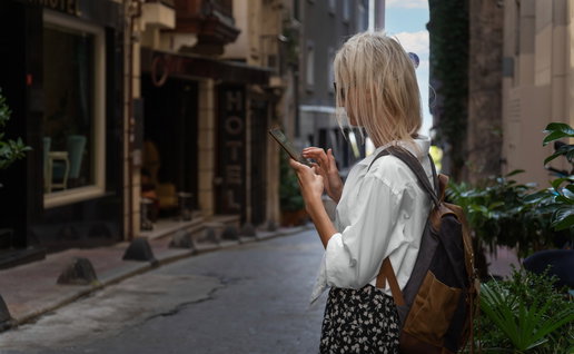 Young female looking at her mobile phone while visiting a beautiful street in Istanbul