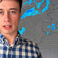 Young man in blue-and-white checkered shirt in front of a weather map of Europe.