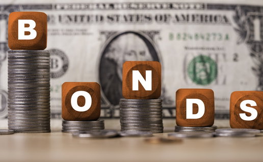 Bonds investment concept with letter blocks on coin stacks and US dollar banknote symbol of fixed income, interest rates, financial markets, portfolio diversification by following with FED strategy.