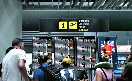 Travellers checking departure boards at a Spanish airport