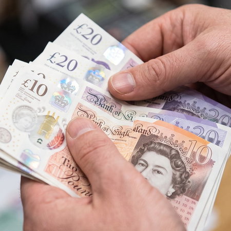 Close-up of hands holding British Pound banknotes