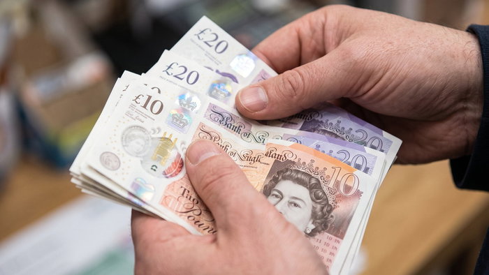 Close-up of hands holding British Pound banknotes
