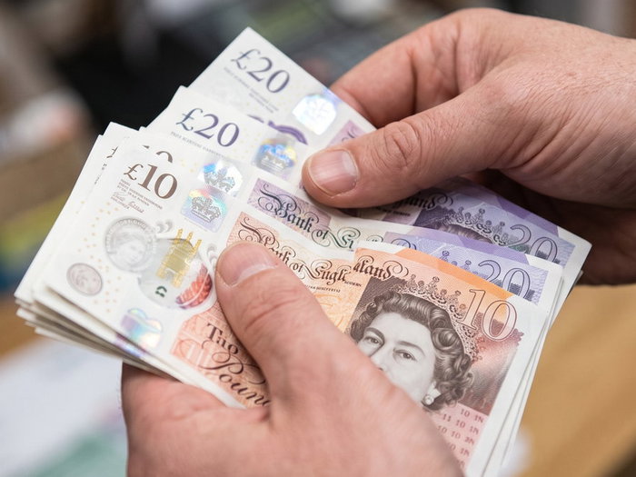 Close-up of hands holding British Pound banknotes