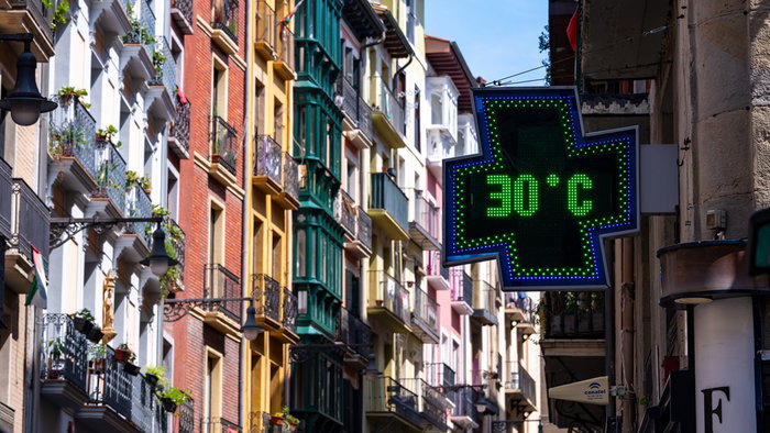Digital thermometer showing 30°C on a sunny Spanish street.