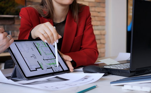 Property professional discussing an apartment floor plan displayed on a tablet.