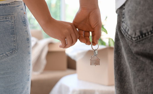 Young couple holding hands and house keys, illustrating proposed property tax cuts for first-time buyers in the Balearic Islands.