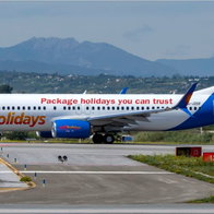 Jet2holidays aircraft on an airport taxiway with mountains in the background.