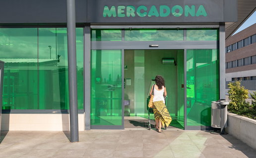 Woman entering a Mercadona supermarket in Spain as the retailer updates its food labels.