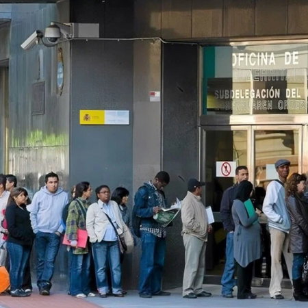 People queuing outside an immigration office in Spain to complete residency paperwork.