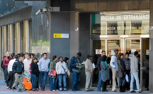 People queuing outside an immigration office in Spain to complete residency paperwork.
