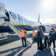 Passengers preparing to board a Ryanair aircraft at an airport.