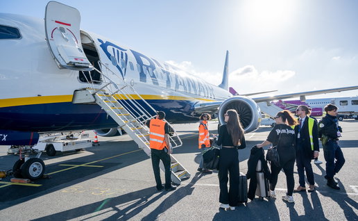 Passengers preparing to board a Ryanair aircraft at an airport.