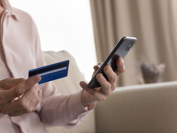 Person holding a bank card and smartphone amid warnings of a phone scam in Spain