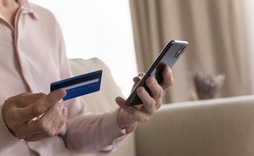 Person holding a bank card and smartphone amid warnings of a phone scam in Spain