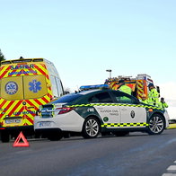 An ambulance, police car and fire truck stationed on a motorway attending an accident
