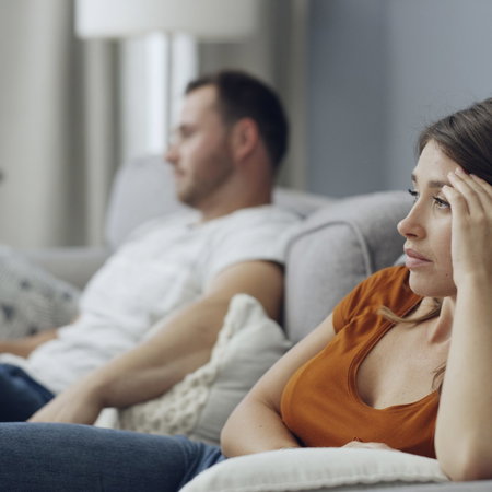 Couple sitting on a sofa not talking to each other after an argument