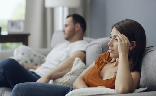 Couple sitting on a sofa not talking to each other after an argument
