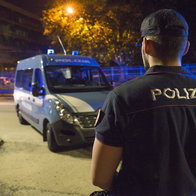 The back of a Police officer in Italy with a police van in front of him