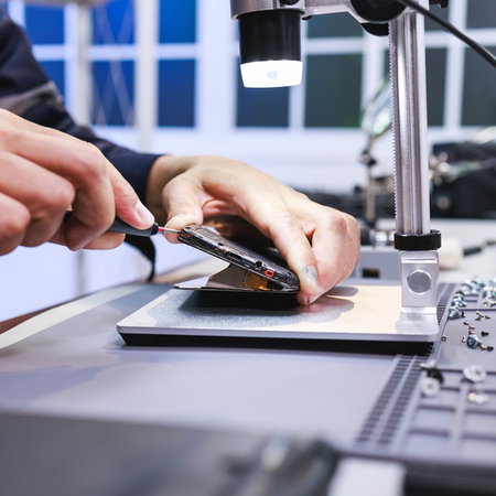 Technician repairing a smartphone in a workshop