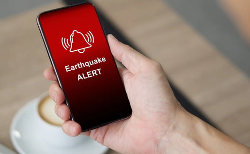 Smartphone displaying an earthquake alert message, illustrating Spain's updated earthquake risk and emergency planning rules.
