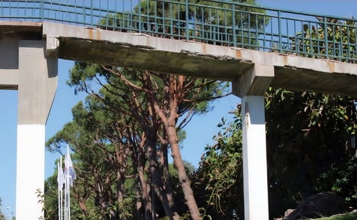Crumbling and rusting footbridge over A7.