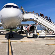 Passengers boarding a Volotea aircraft via mobile stairs at an airport.