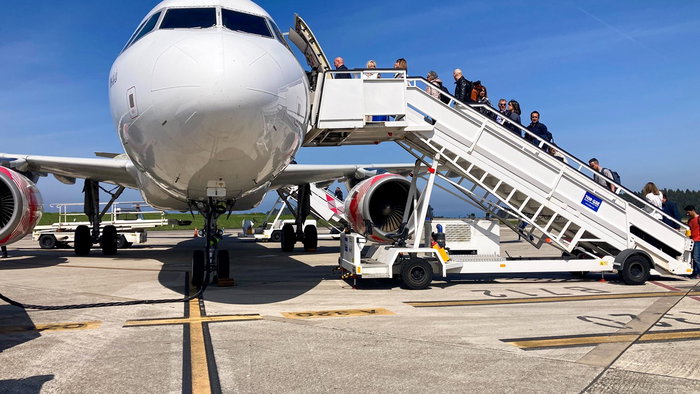 Passengers boarding a Volotea aircraft via mobile stairs at an airport.